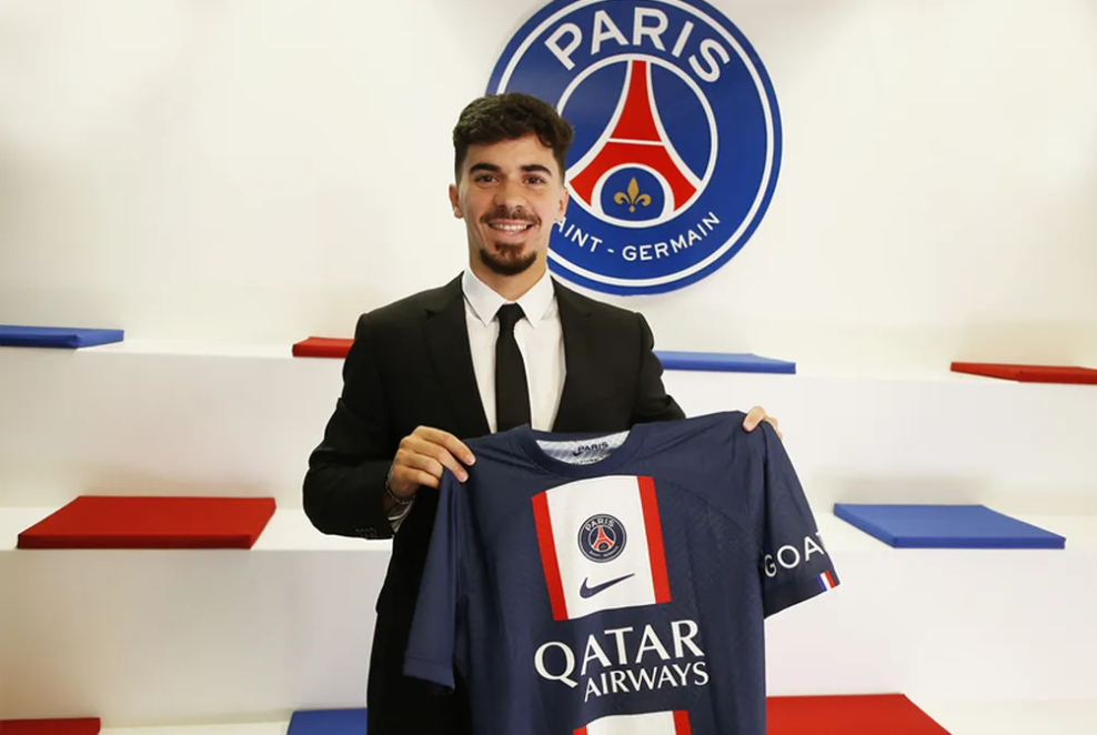 Vitinha segurando a camiseta do contrato recém-assinado com o clube Paris Saint-Germain